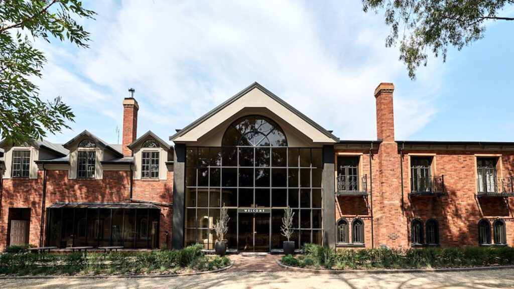 The elegant brick facade of The Trawool Estate, featuring huge modern windows alongside charming heritage-style windows, one of country Victoria's best luxury accommodation - Luxury Escapes