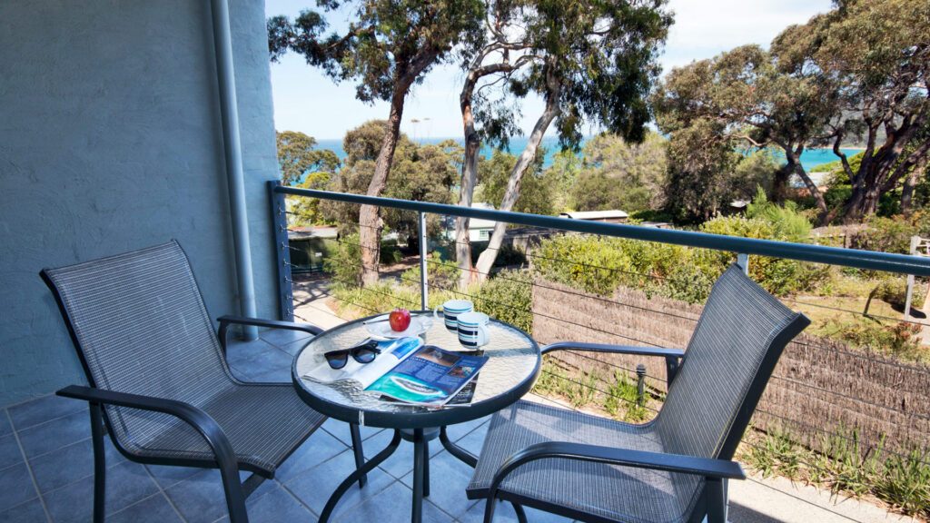 View overlooking the Victoria native trees through to the ocean from the balcony of the Lorne Surf Apartments, which is one of country Victoria's best luxury accommodation - Luxury Escapes