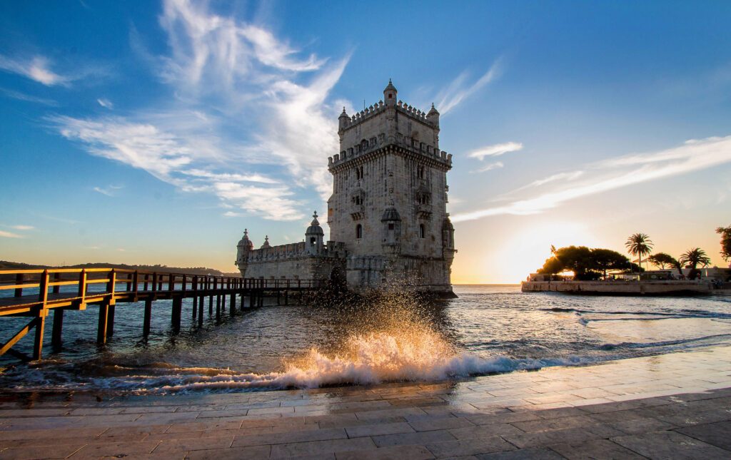 Small waves lapping the cobblestoned banks of the Belem Tower in Lisbon - Luxury Escapes 