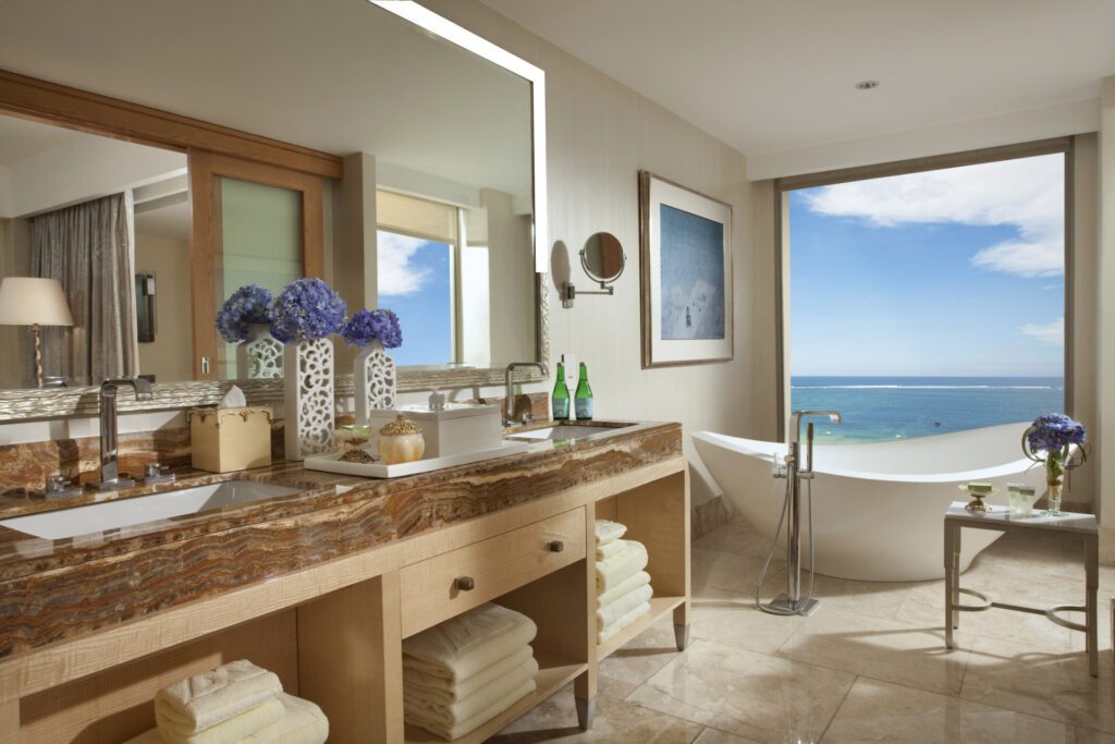 View from the bathroom of the Royal Suite at The Mulia, overlooking the turquoise ocean from the standalone bathtub - Luxury Escapes