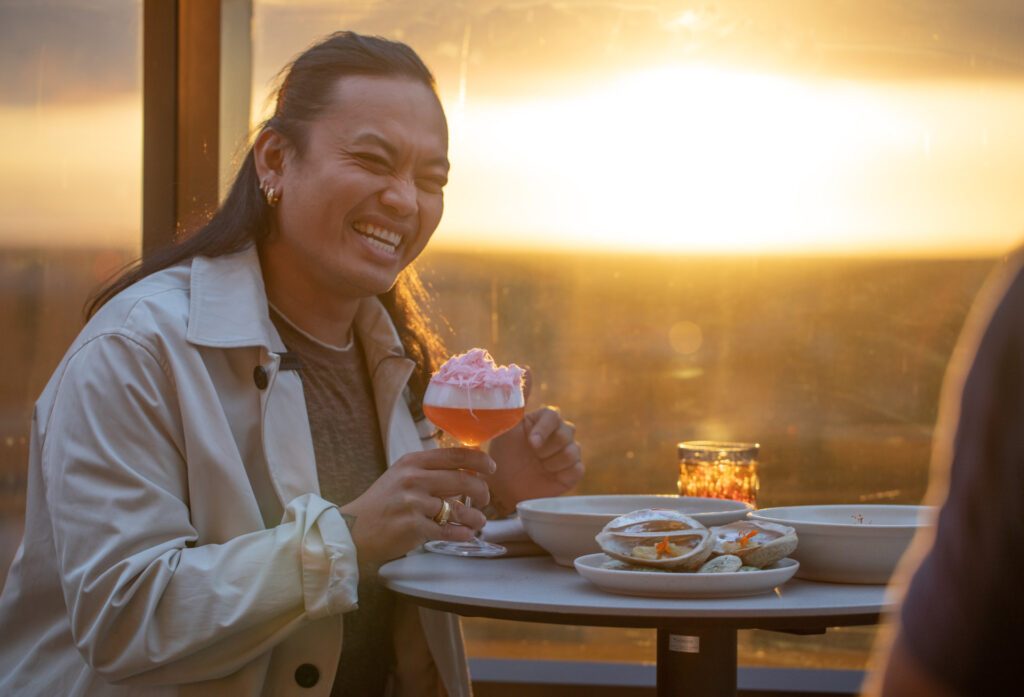 Adelaide's top restaurants with MasterChef Khanh Ong enjoying a sundowner at Sol Rooftop Bar with an exquisite drink - Luxury Escapes