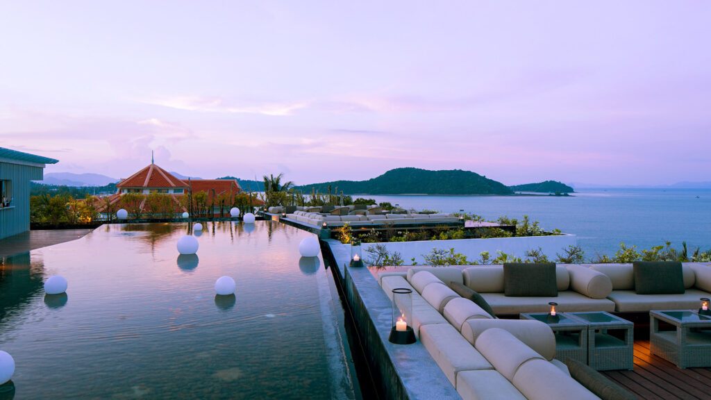 The pool overlooking the ocean at sunset at Amatara Wellness Resort, one of the best honeymoon resorts in Thailand
