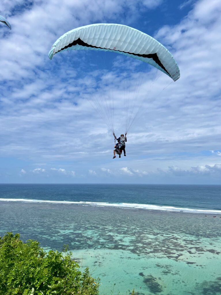 Paragliding over the water in Nusa Dua, one of the best things to do to make your Bali escape unforgettable