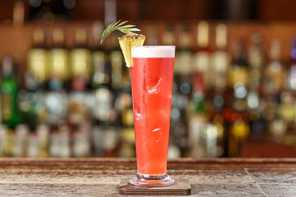 Singapore Sling in a tall glass, a drink originally invented at Raffles Singapore's Long Bar - Luxury Escapes