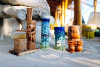 A collection of characterful tiki mugs at Azure Beach Club Legian, Bali - Luxury Escapes