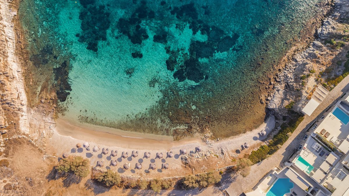 An aerial shot of the beach and Casa Del Mar Mykonos Seaside Resort in Mykonos, one of the best Greek islands - Luxury Escapes