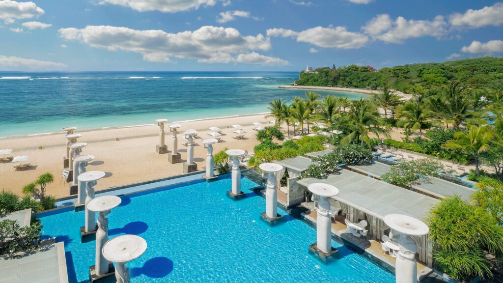 View of the Oasis pool looking out over the beach and ocean at The Mulia, to illustrate an article about The Mulia Bali - Luxury Escapes