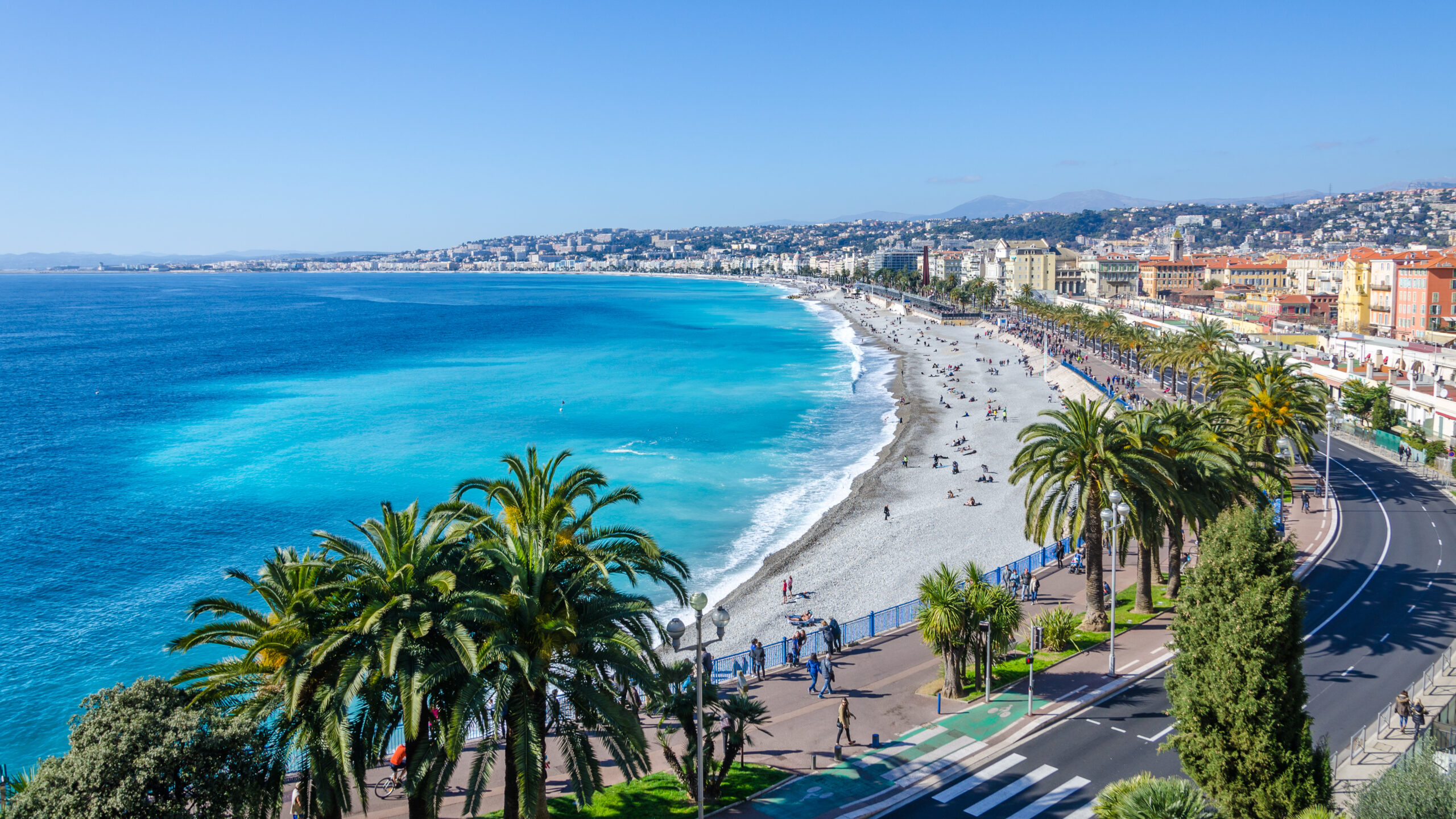 View of Nice from above with blue water on the left and a long boulevard on the right