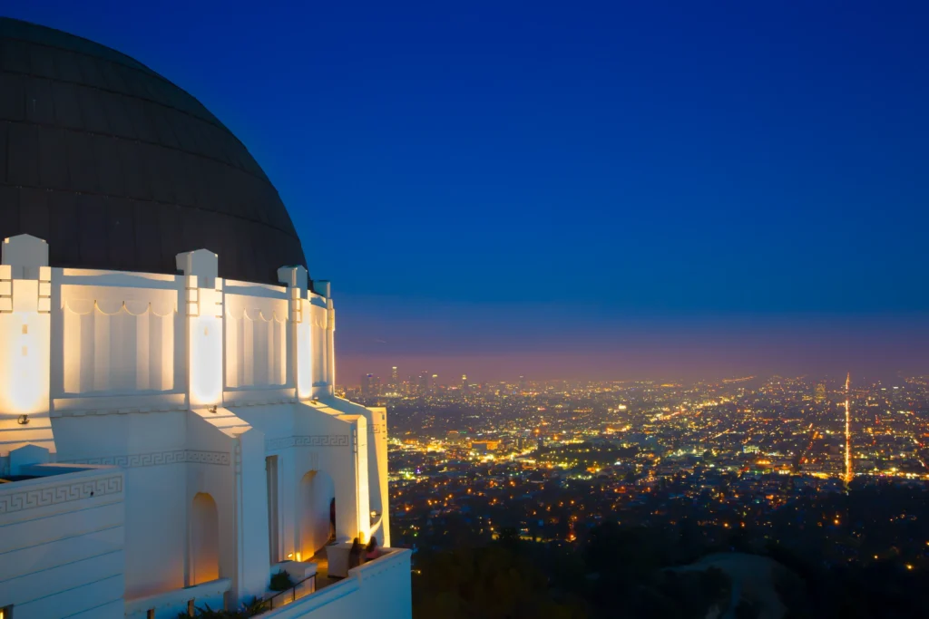 The dazzling Los Angeles city lights illuminate the Griffith Observatory which is seen in many iconic movies - Luxury Escapes