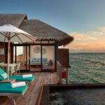 Private water villa with an infinity pool at sunset - Luxury Escapes