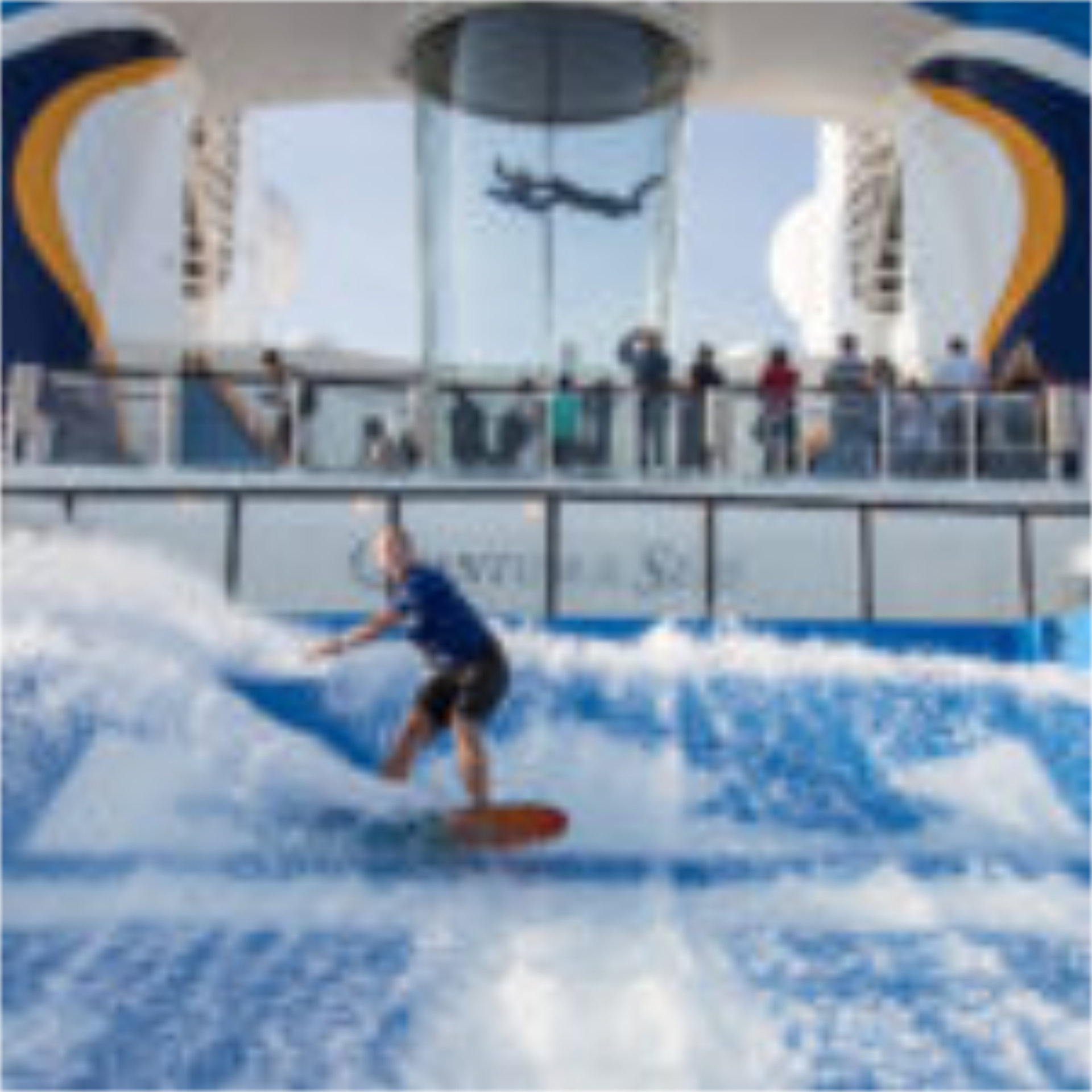 A kid hangs ten at the Flow Rider surf experience on a Royal Caribbean cruise - Luxury Escapes