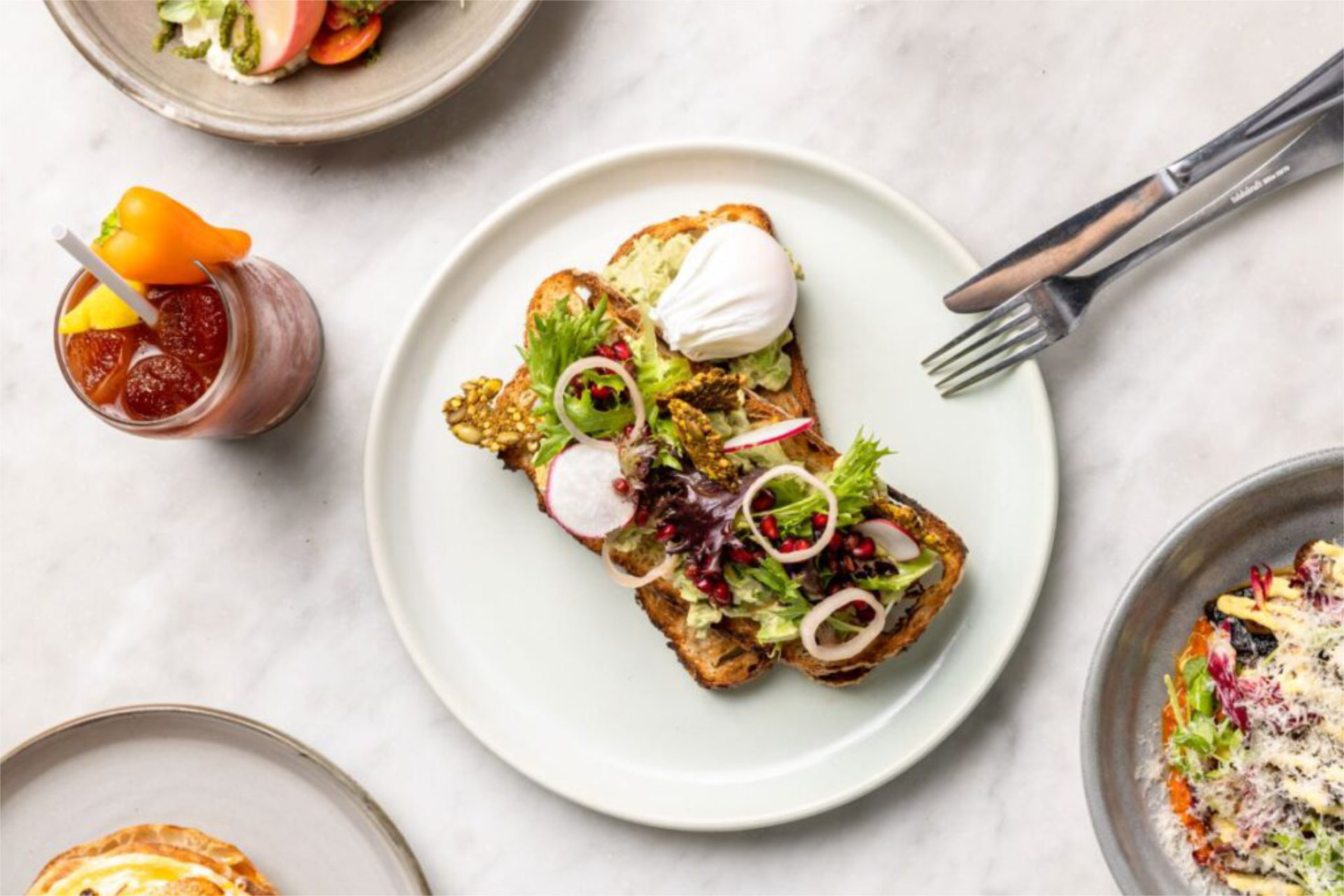 A selection of drinks and meals on a table at Kettle Black which is one of the top weekend brunch spots in Melbourne - Luxury Escapes