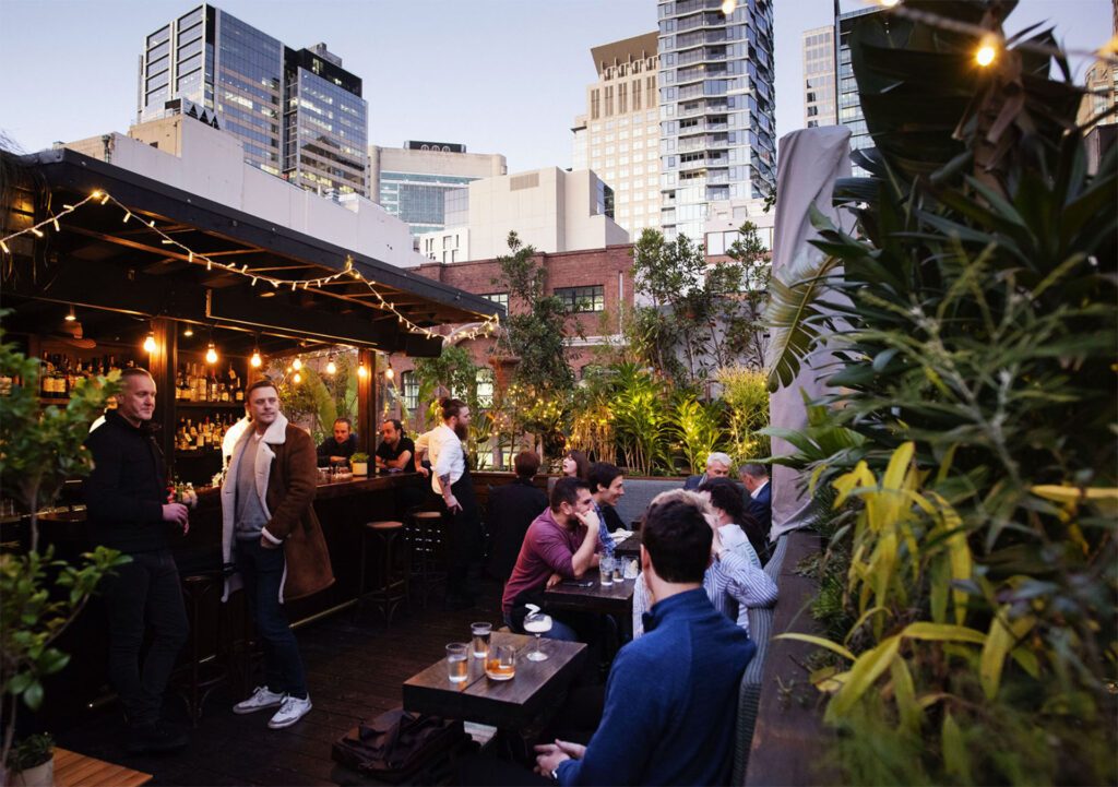 Guests enjoying drinks in the leafy beer garden of Old Mate's Place, one of Sydney's top 10 bars in 2023 - Luxury Escapes