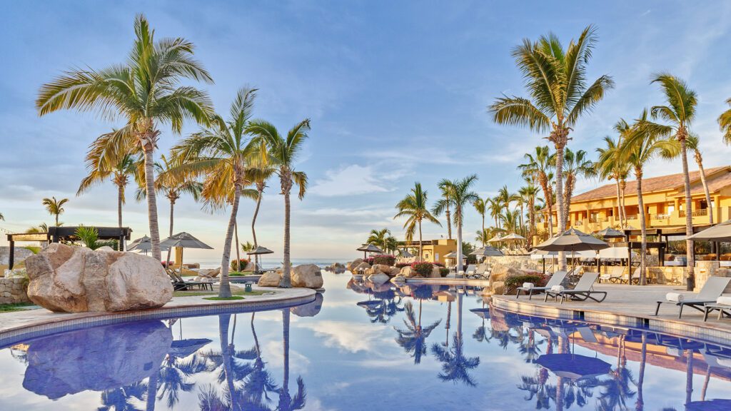 The outdoor pool surrounded by palm trees at Grand Fiesta Americana Los Cabos All Inclusive Golf & Spa, Mexico and one of the Best All Inclusive Resorts of All Time - Luxury Escapes
