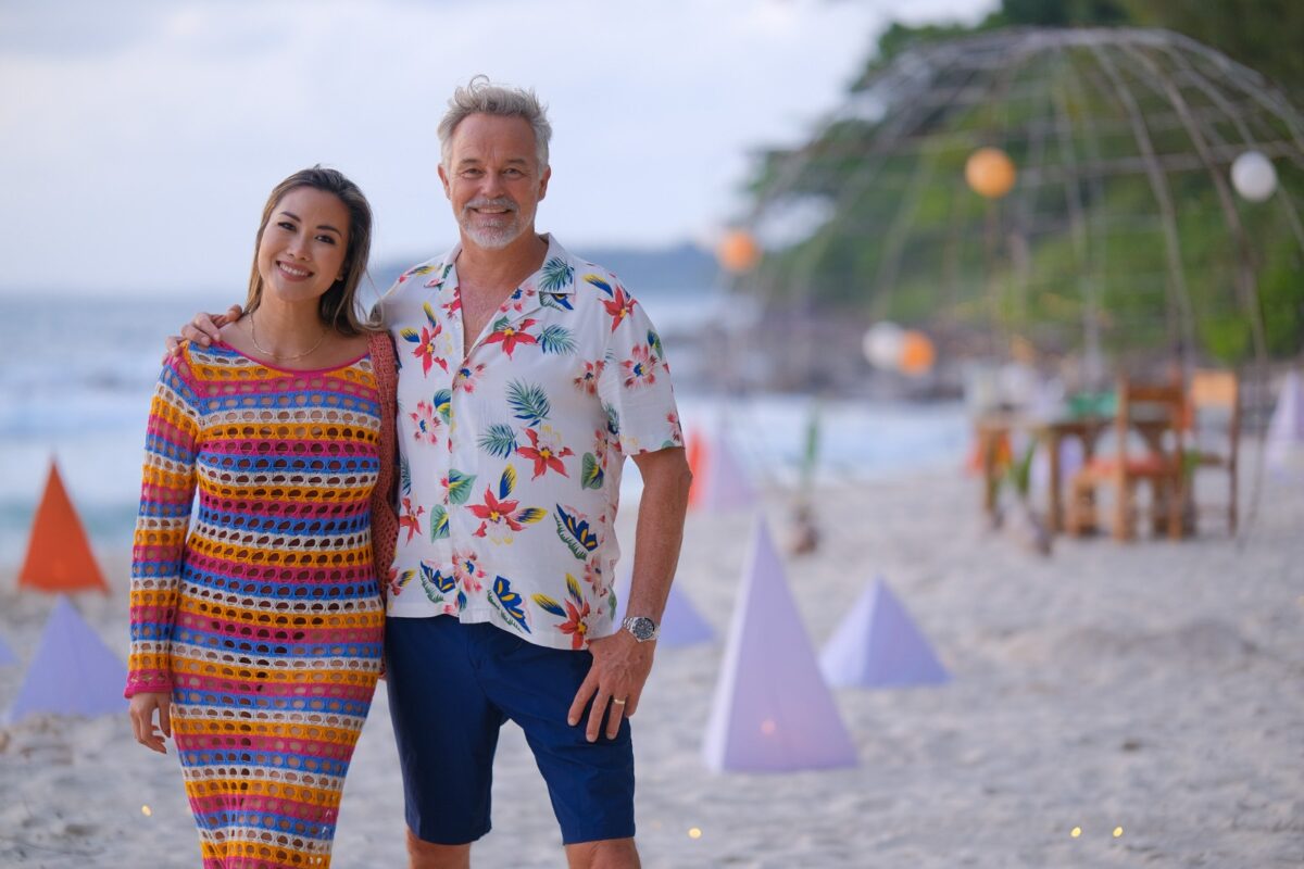 Diana Chan and Cameron Daddo posing on a Thai beach at sunset, one of their favourite places to visit in Thailand - Luxury Escapes