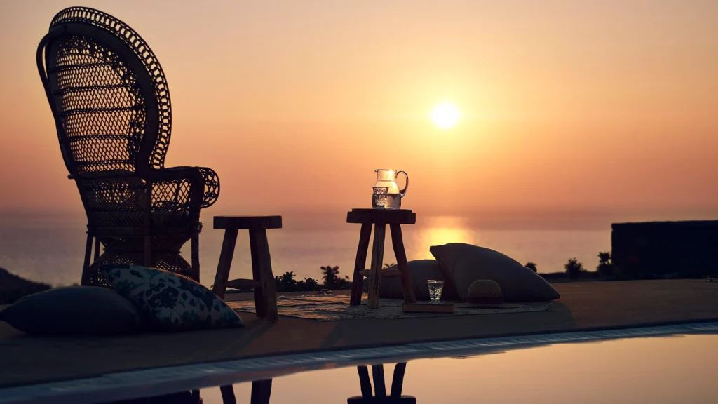 A poolside sun set view from Santo Pure Oia Villa & Suites, one of the best places to stay in Greece - Luxury Escapes