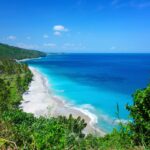 A view of a beach and blue sky in Lombok, one of the best islands to visit in Indonesia - Luxury Escapes