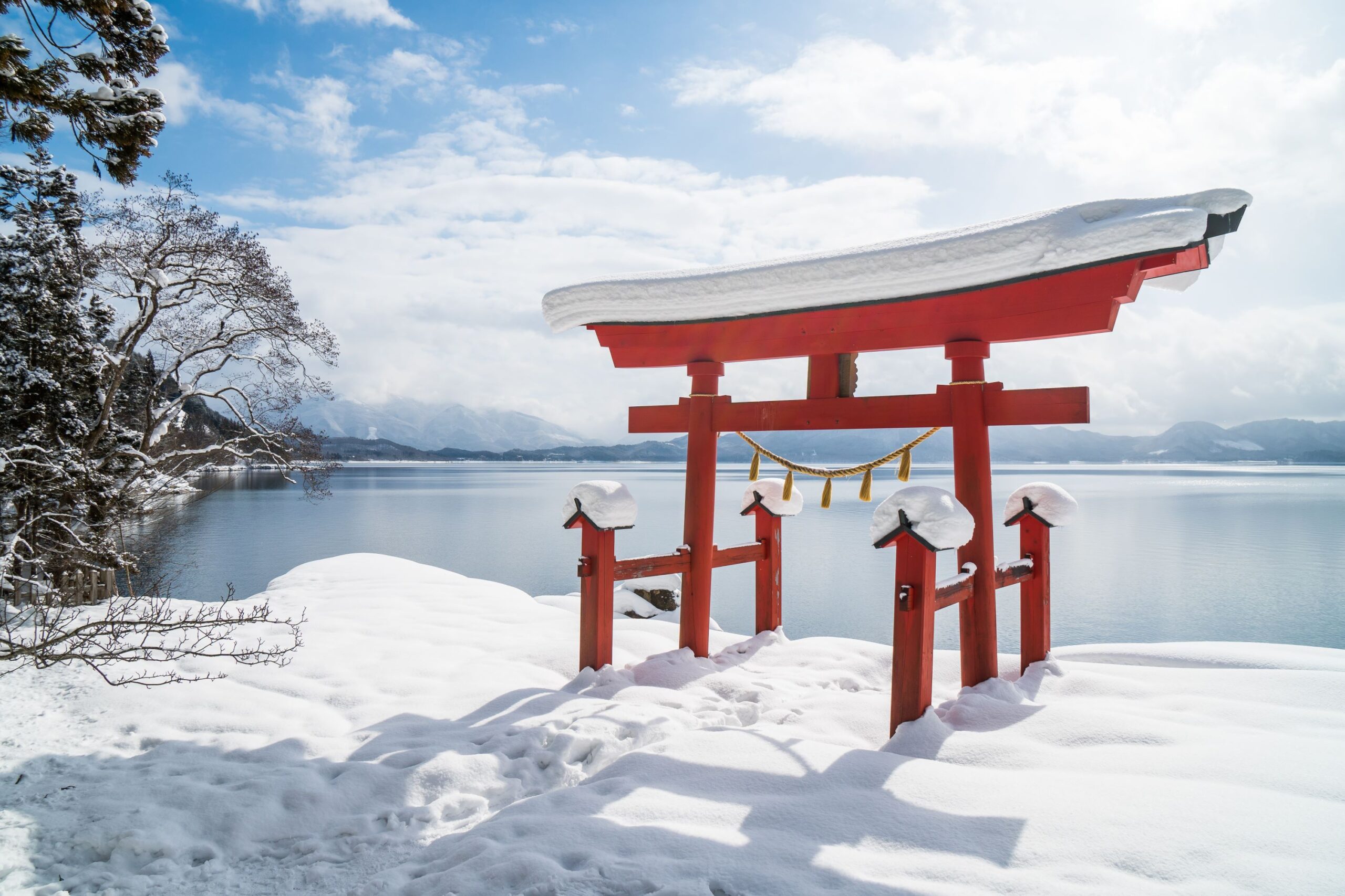 Torii gate in front of Lake Tazawa, Akita Prefecture, a perfect winter activity in Japan.