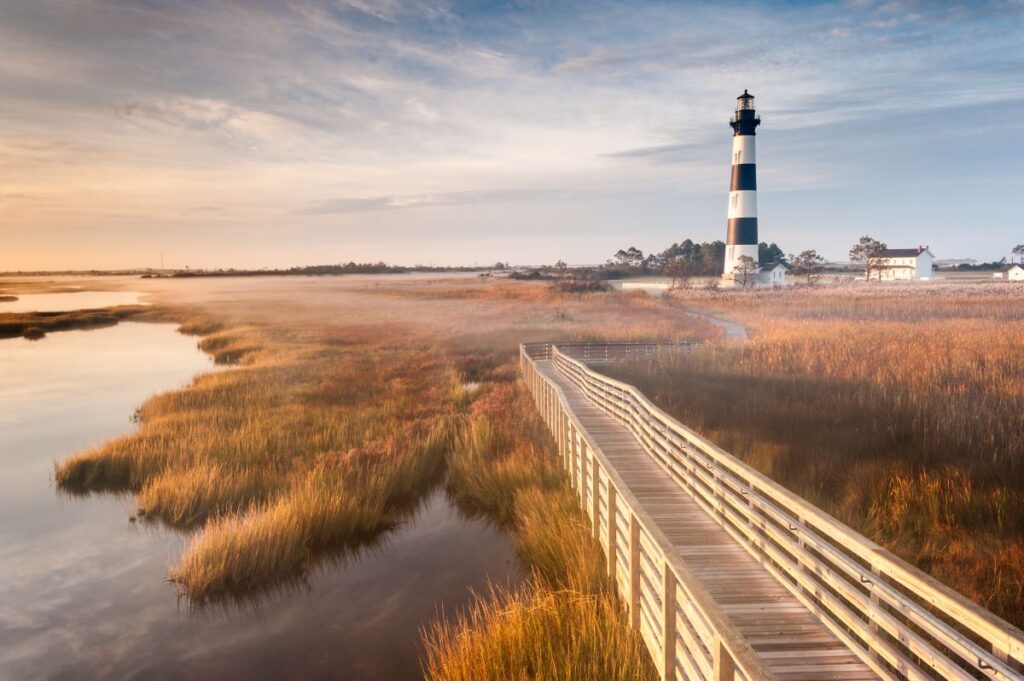 A walk through the marshlands to Bodie Island's striking monochromatic lighthouse is a must for visitors to the Outer Banks of North Carolina in USA, a sun-seeker's dream - Luxury Escapes