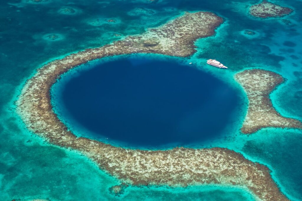 The Great Blue Hole is one of the most astounding diving sites on the Belize Barrier Reef, a world-class stop for sun-seekers in the Caribbean - Luxury Escapes