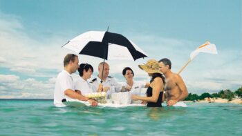 Cruise passengers enjoying caviar in the surf, one of the surprising experiences on Seabourn cruises - Luxury Escapes