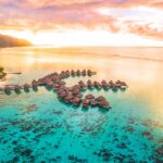 An aerial shot of overwater villas in a lagoon in Moorea, Tahiti, French Polynesia, where more Australians are travelling - Luxury Escapes