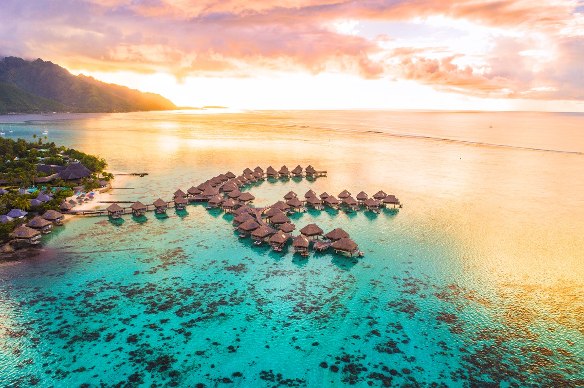 An aerial shot of overwater villas in a lagoon in Moorea, Tahiti, French Polynesia, where more Australians are travelling - Luxury Escapes