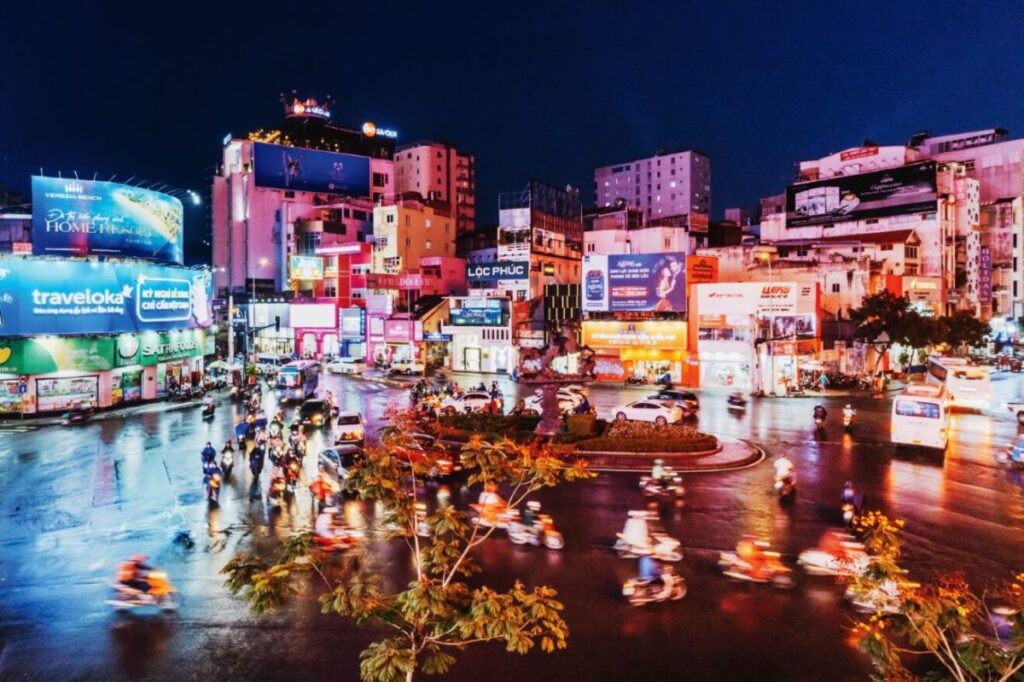 Motorbike riders make their way through the light-filled Ho Chi Ming City centre, some of which taking part in food tours - Luxury Escapes