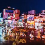 Motorbike riders make their way through the light-filled Ho Chi Ming City centre, some of which taking part in food tours - Luxury Escapes