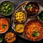 A delicious spread of North Indian delicacies like butter chicken, palak paneer, jeera alu, specially found in India's Golden Triangle – Luxury Escapes