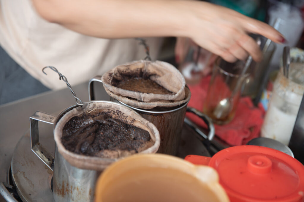 Vietnamese coffee being filtered by a street vendor - Luxury Escapes