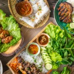 Assorted Vietnamese food spread out on several plates, photographed from above