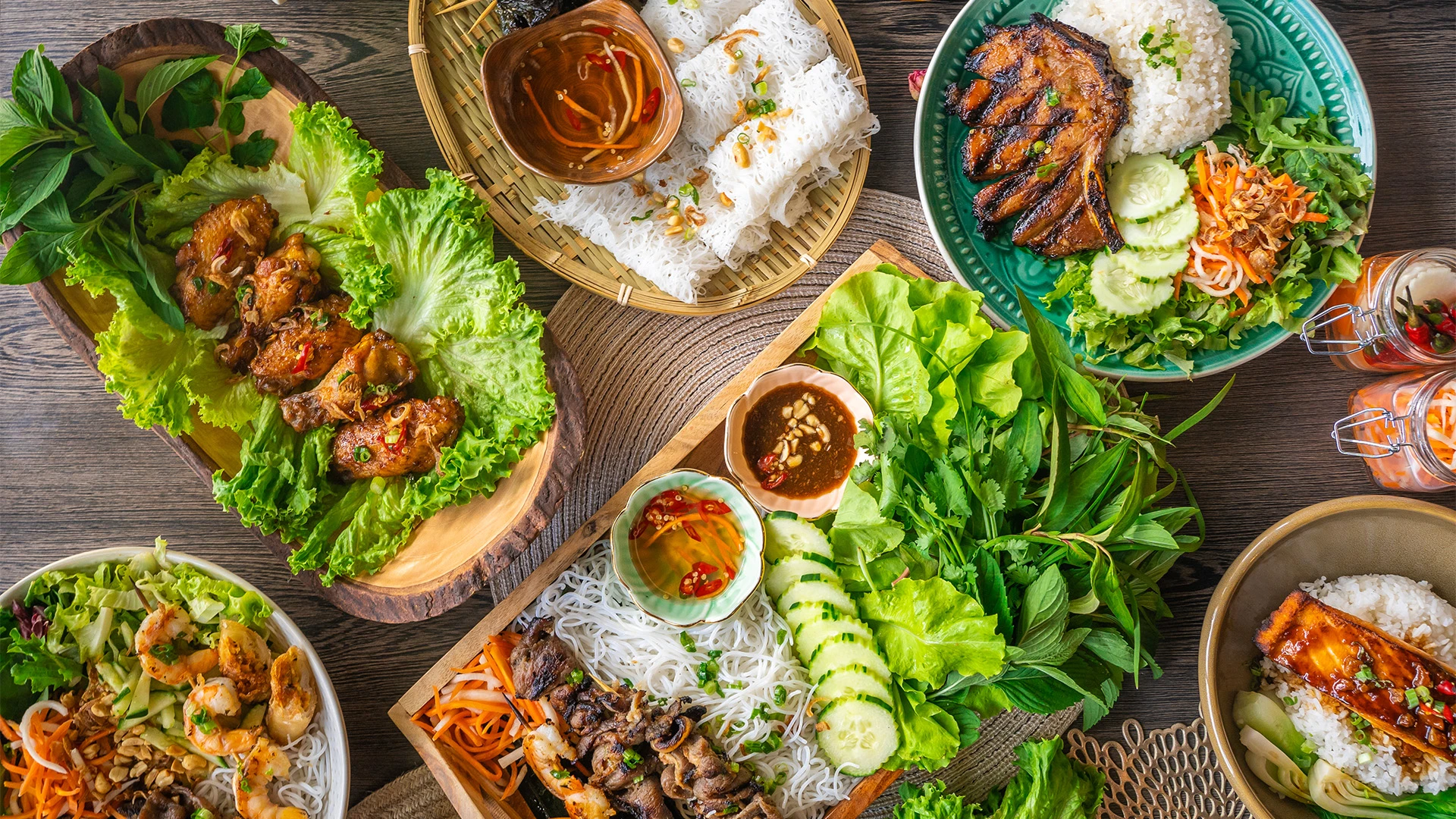 Assorted Vietnamese food spread out on several plates, photographed from above