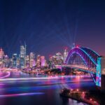 View of the Sydney Harbour Bridge illuminated during the Vivid Sydney festival celebrations - Luxury Escapes