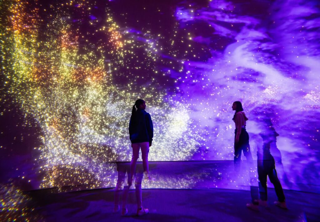 Two people standing in an interactive lights display at Vivid Sydney festival - Luxury Escapes 