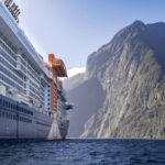 The side of Celebrity Edge cruising through Milford Sound, one of the best ways to explore New Zealand - Luxury Escapes