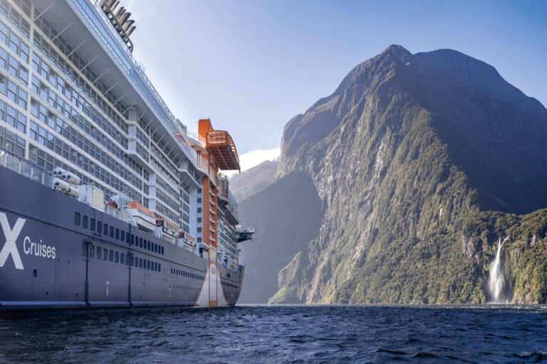 The side of Celebrity Edge cruising through Milford Sound, one of the best ways to explore New Zealand - Luxury Escapes