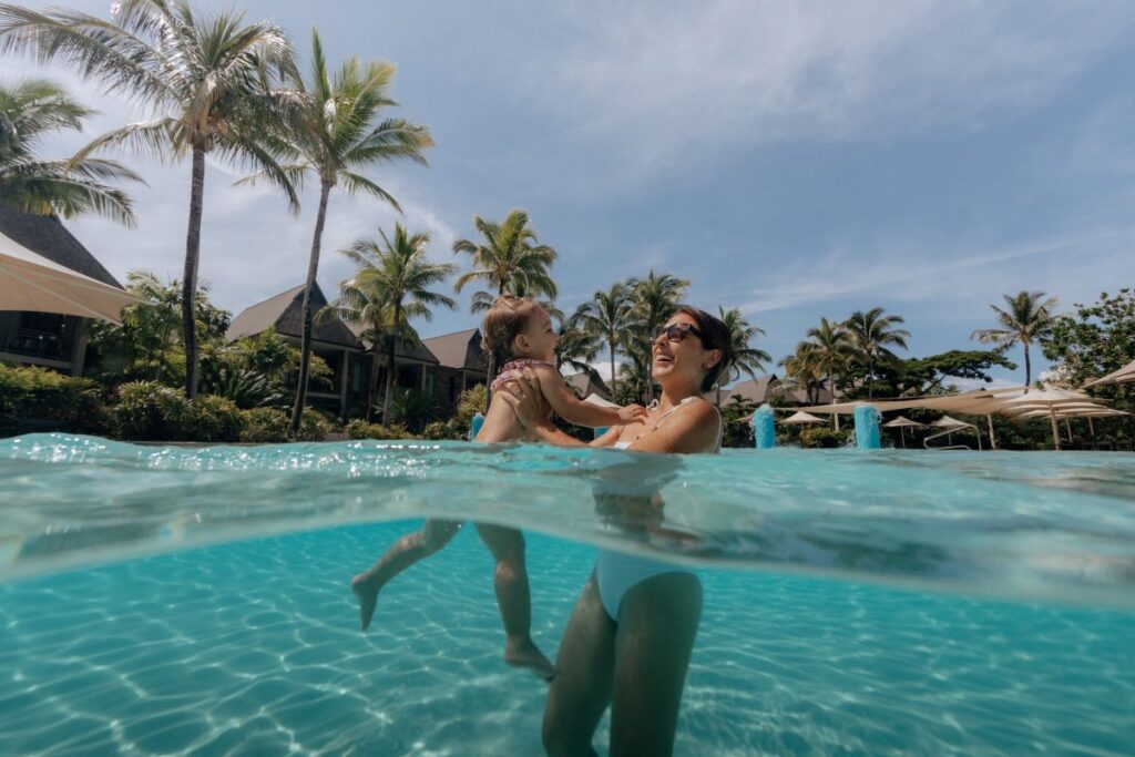 A mother plays with her baby in the pool at InterContinental Fiji Golf Resort & Spa, an IHG Hotel, one of the best places to stay with exploring Fiji - Luxury Escapes