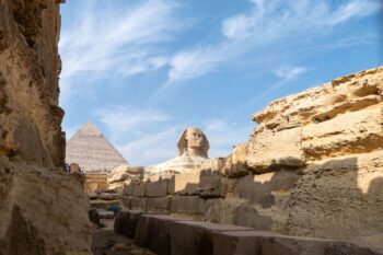 The Great Sphinx of Giza with the Pyramids in the background, some of Egypt's most significent attractions - Luxury Escapes