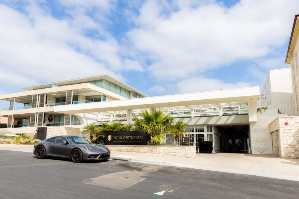 A shot of the front facade of InterContinental Sorrento Mornington Peninsula with a sports car parked in front, one of the best escapes in the Mornington Peninsula - Luxury Escapes