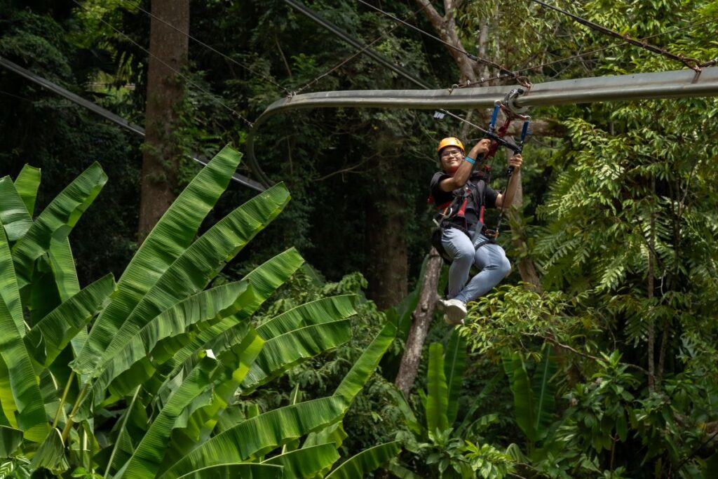 A man hangs from a zipline at Hanuman World, one of the best activities to do in Phuket - Luxury Escapes