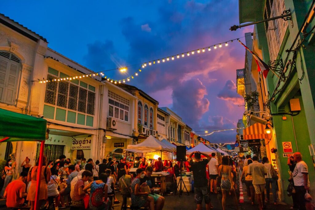 A crowd of people wander through a market in Phuket, one of the best activities to do in the city - Luxury Escapes