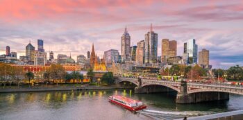The Melbourne skyline at sunset, with a boat in the Yarra Valley - Luxury Escapes