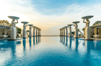 Two rows of statued women stand either side of the pool at The Mulia, Bali, one of the world's best resorts - Luxury Escapes
