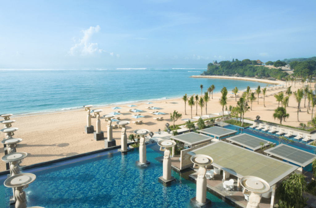 The sweeping beachfront and large pool surrounded by stone statues at The Mulia in Bali, one of the world's best resorts - Luxury Escapes