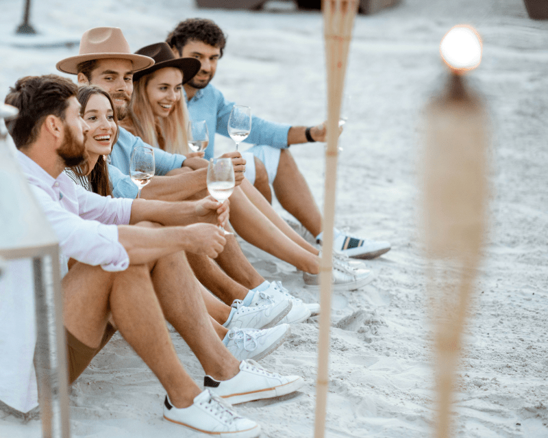 A group of friends enjoying wine on the beach in the Margaret River Region - Luxury Escapes