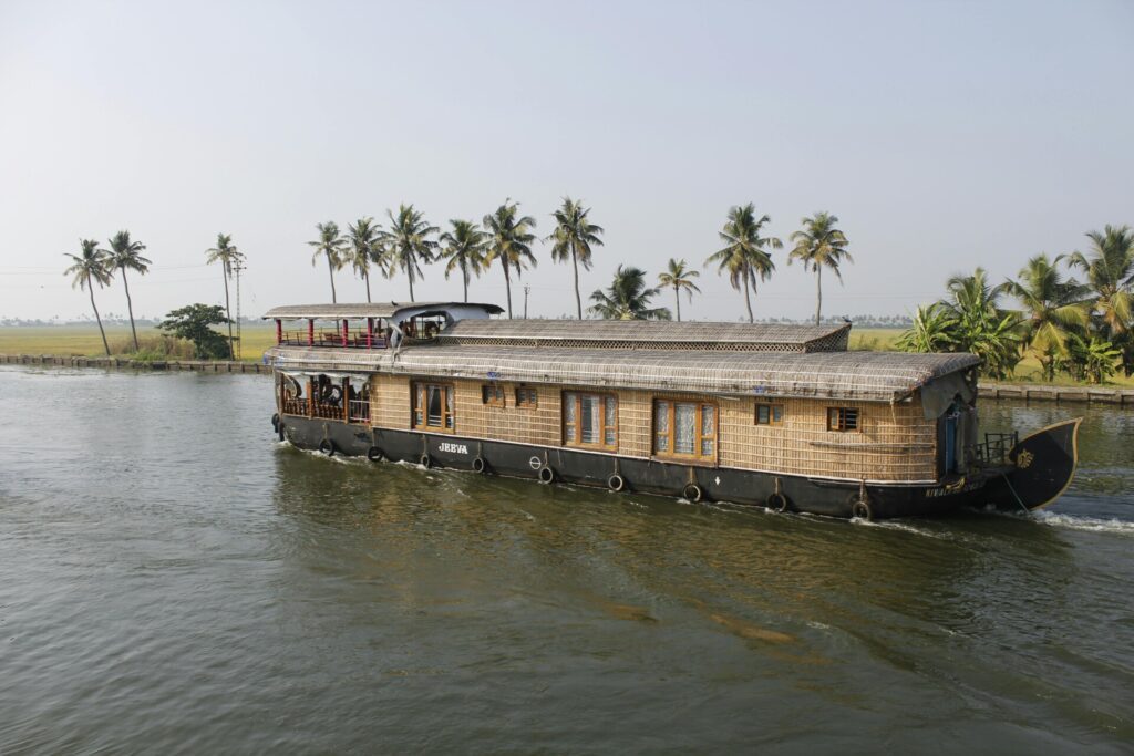 A traditional houseboat on the backwaters of Kerala - Luxury Escapes