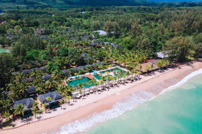 The palm-fringed beachfront infinity pool at Beyond Resort Khaolak, one of Thailand's best hotels. - Luxury Escapes