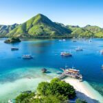 View of Kelor Island within Komodo National Park with Phinisi Boats in the water - Luxury Escapes