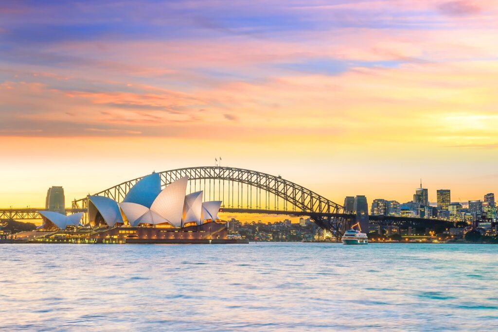 The sunset at the Darling Harbour in Sydney, looking over the Harbour Bridge and the Opera House, one of the best things to do in Sydney - Luxury Escapes